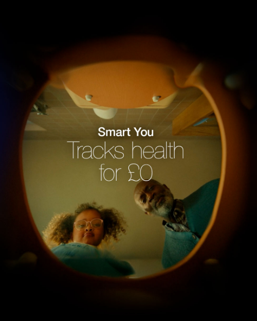 An image of a loo seat from the underneath looking up out of the toilet bowl. the edges are dark so it is a stylised image and you can just see the underside of a wooden loo seat. In the opening there is an older man and young girl leaning down over it. There's white text in the middle with 'Smart You' in bold above 'Tracks health for £0'.